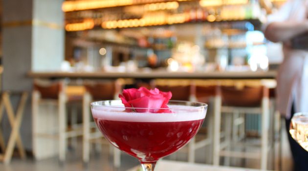 Photo of a cocktail surrounded by roses